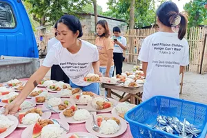 Volunteers serving meals to Filipino children in Cebu